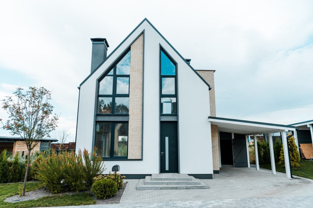 new luxury house near green trees and bushes on grass